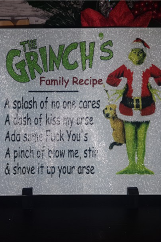 "8x11 glass cutting board featuring a Grinch's Family Recipe design in vibrant colors. Durable, heat-resistant, and festive, perfect for holiday cooking or decor."