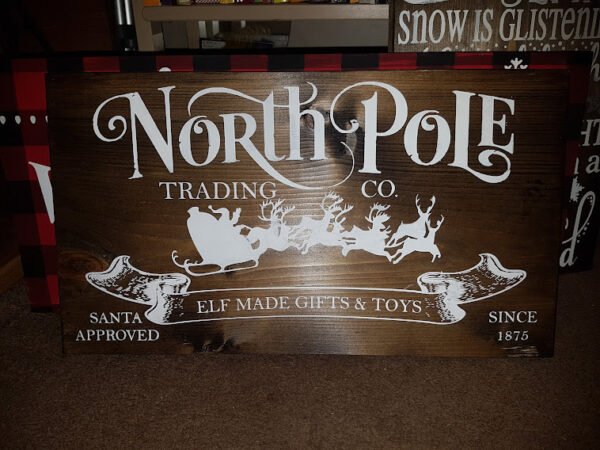 1.	North Pole Trading Company Christmas Sign | Handpainted 9.25x16 Stained Wood | Rustic Farmhouse Holiday Décor Handpainted stained solid pine wood Christmas sign reading “North Pole Trading Company” in vintage-style festive lettering.