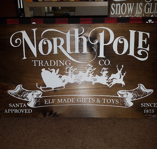 1.	North Pole Trading Company Christmas Sign | Handpainted 9.25x16 Stained Wood | Rustic Farmhouse Holiday Décor Handpainted stained solid pine wood Christmas sign reading “North Pole Trading Company” in vintage-style festive lettering.